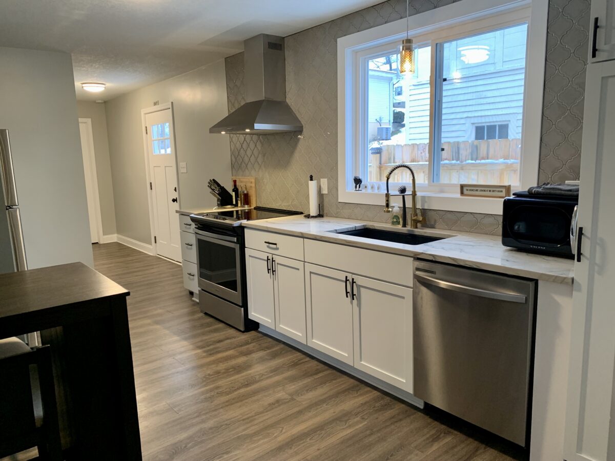 A modern kitchen, with silver appliances and a wooden floor.