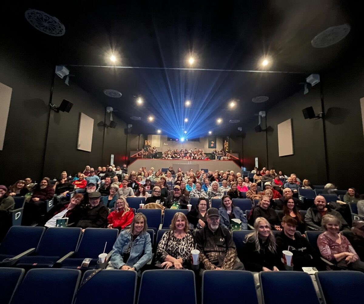 Viewers gather in a theater for the premier of a locally produced film.