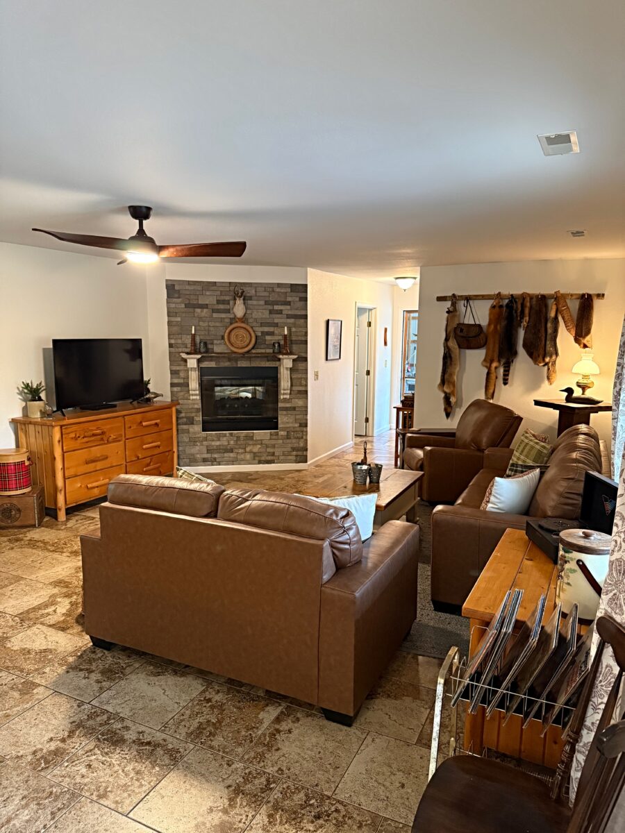 A living room with couches and chairs, and a television on a dresser.
