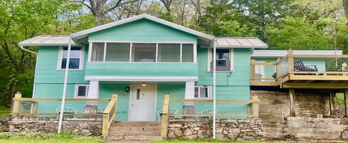 The exterior of a green and tan house.