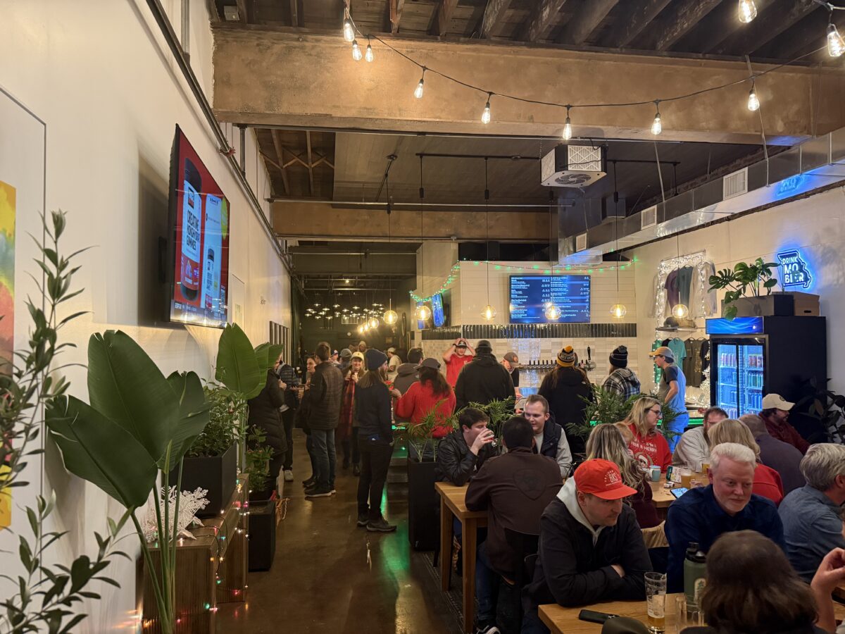 A crowd of people seated and standing in a bar.