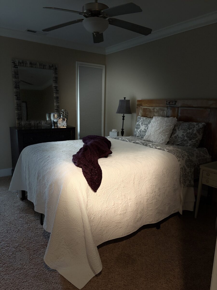 A bedroom with a made bed and amenities.