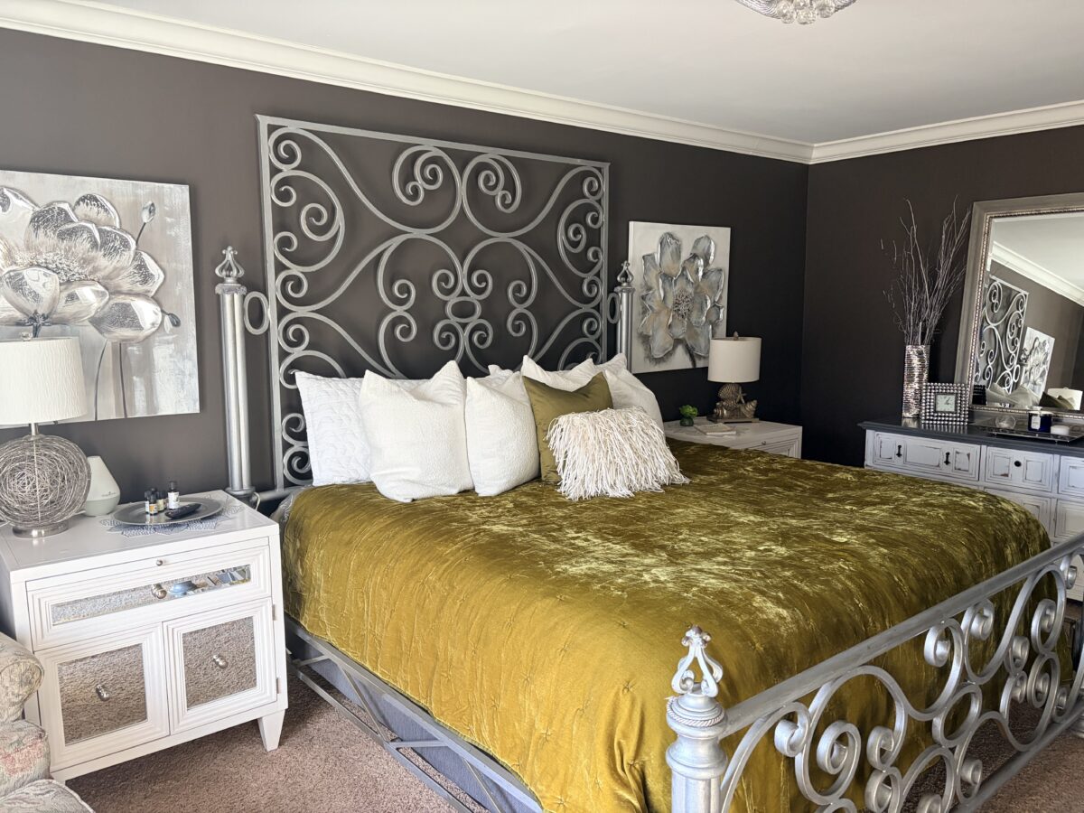 A primary suite with a made bed and amenities.
