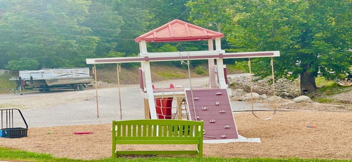 Playground equipment and a green bench.