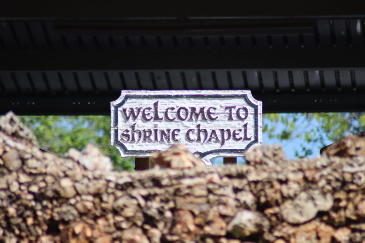 A sign over a rocky ledge reading "Welcome to Shrine Chapel."