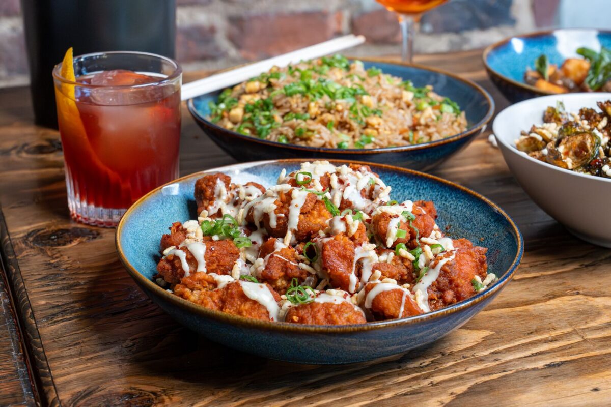 American cuisine, including crispy glazed wings and seasoned fried rice, paired with handcrafted cocktails at Stews Food & Liquor, located in the heart of Soulard, St. Louis.