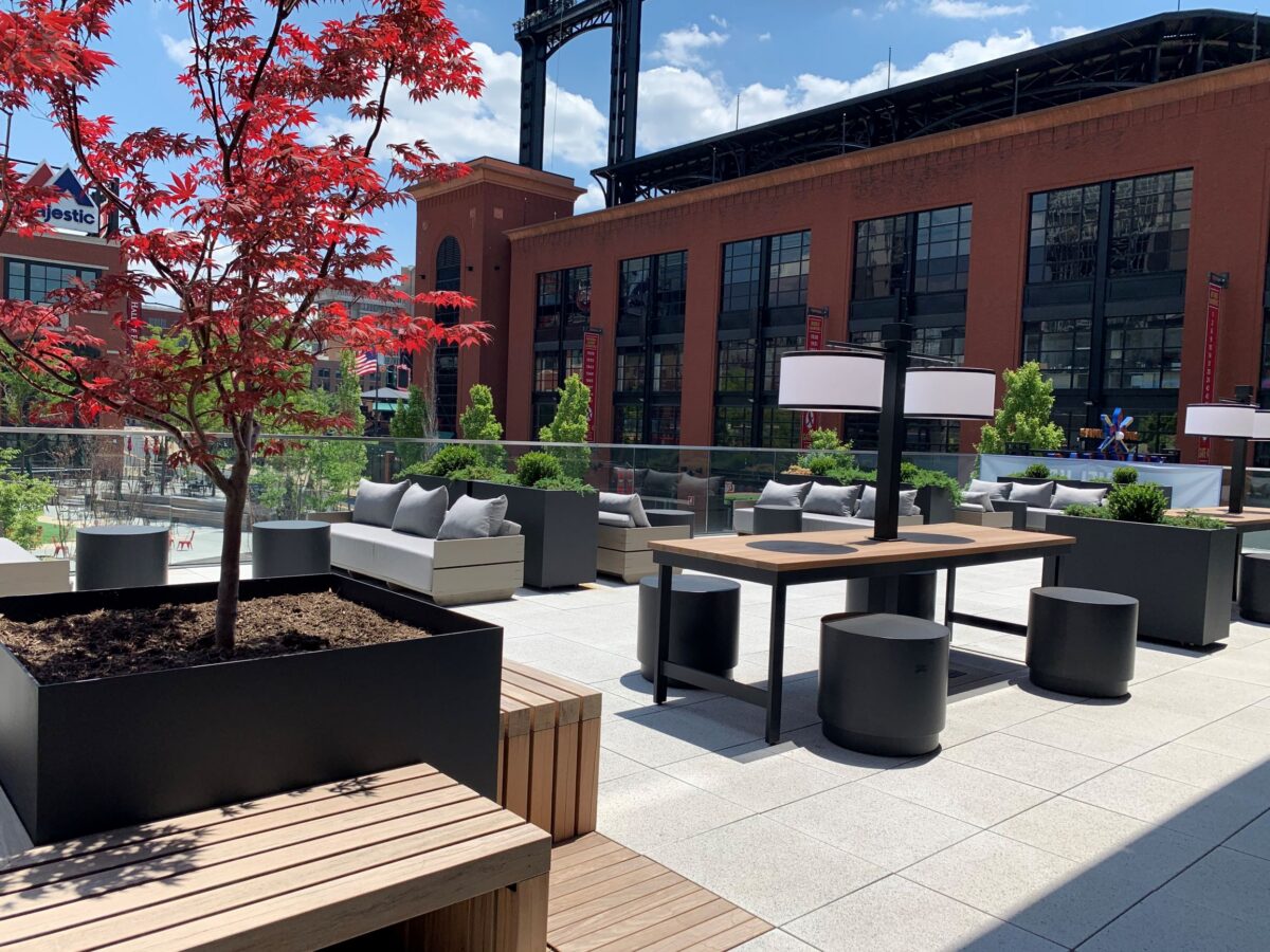 Outdoor eating and meeting space with tables and chairs.