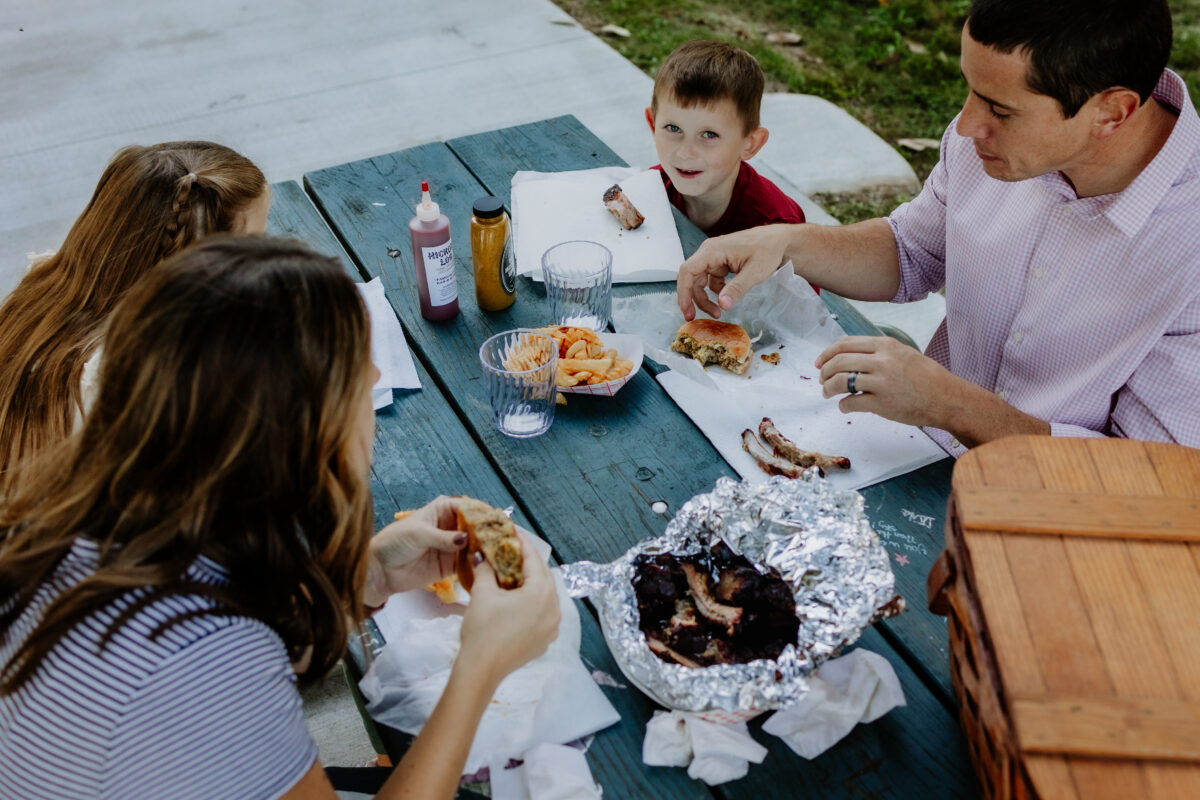Two children and two adults enjoy a meal outside.