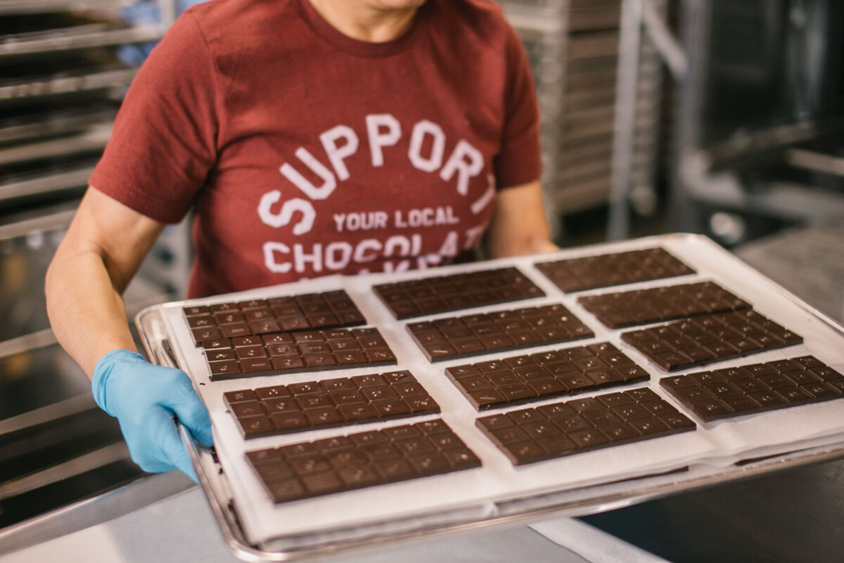 Freshly molded chocolate bars displayed on a paper-lined tray