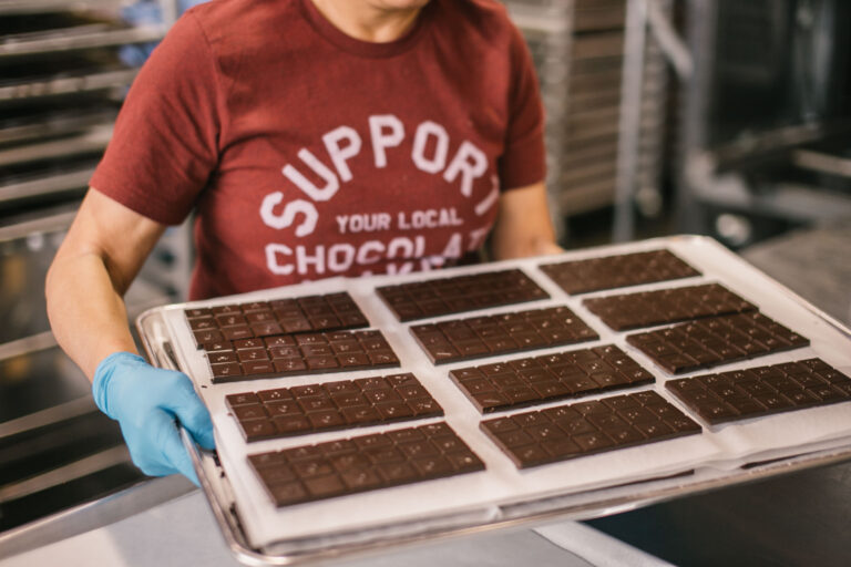 Freshly molded chocolate bars displayed on a paper-lined tray