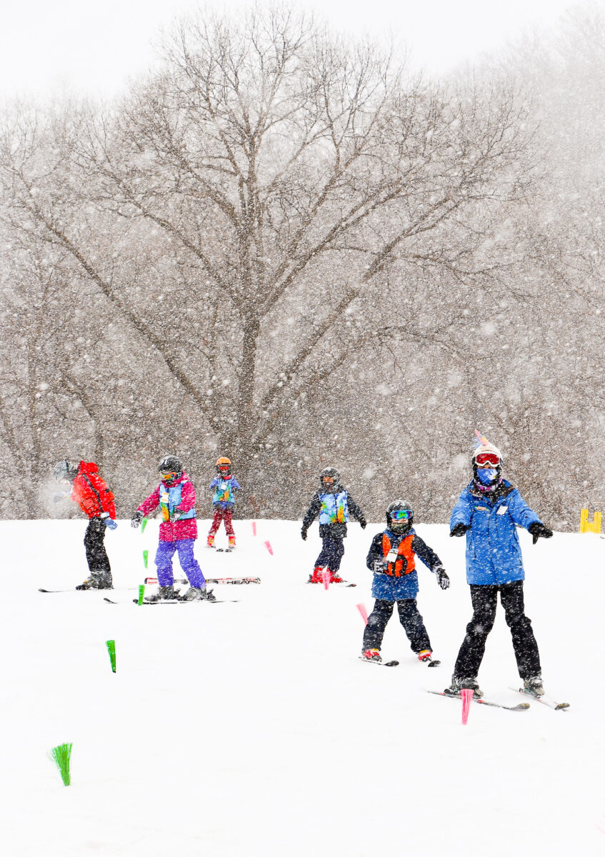 People skiing down a snowy hill.