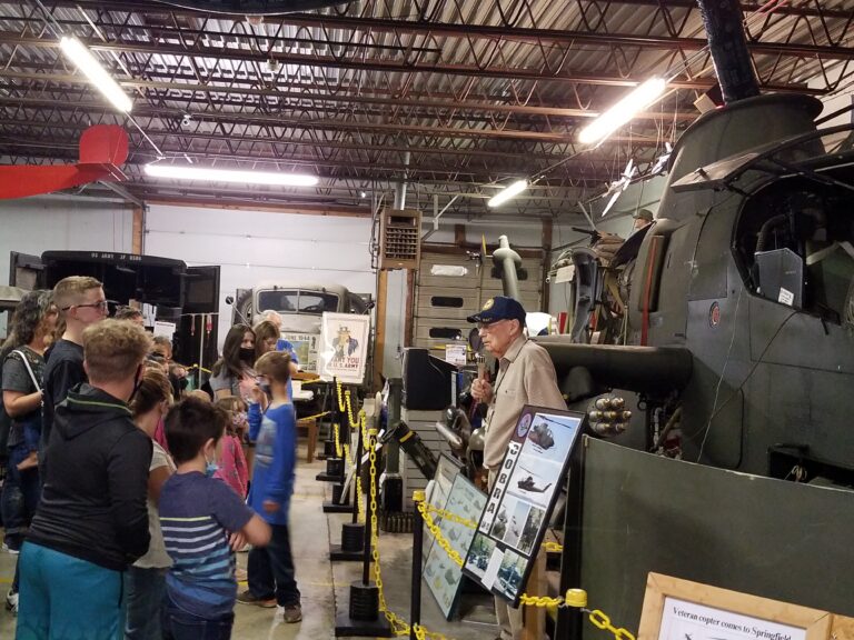 Ron Cutter explaining the Cobra Helicopter to a group of visitors.
