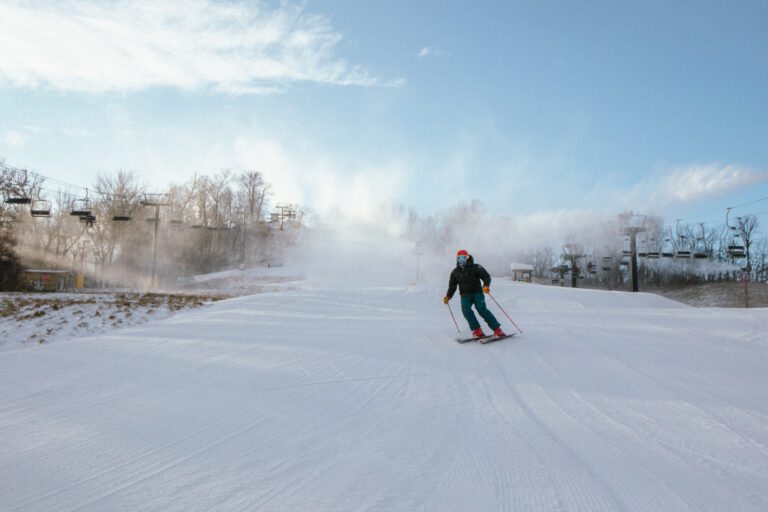 A person skis down a snowy slope.