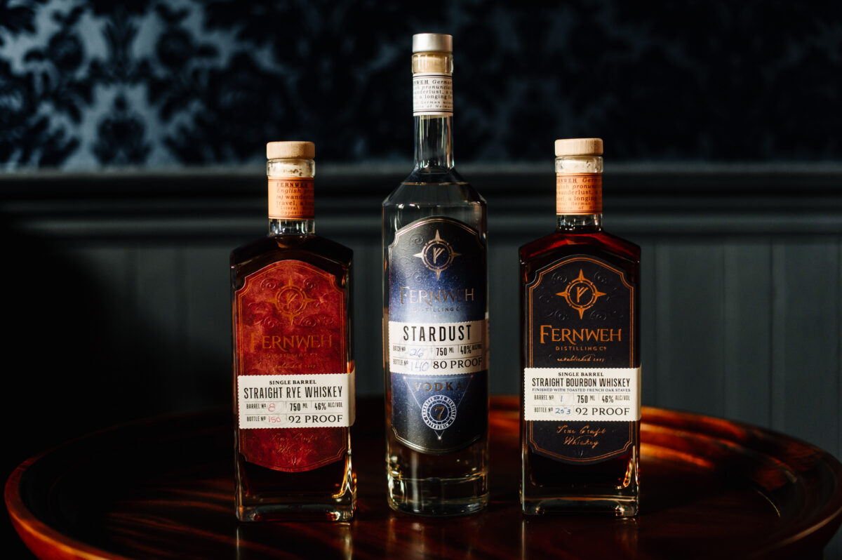 Three bottled spirits lined up on a table.