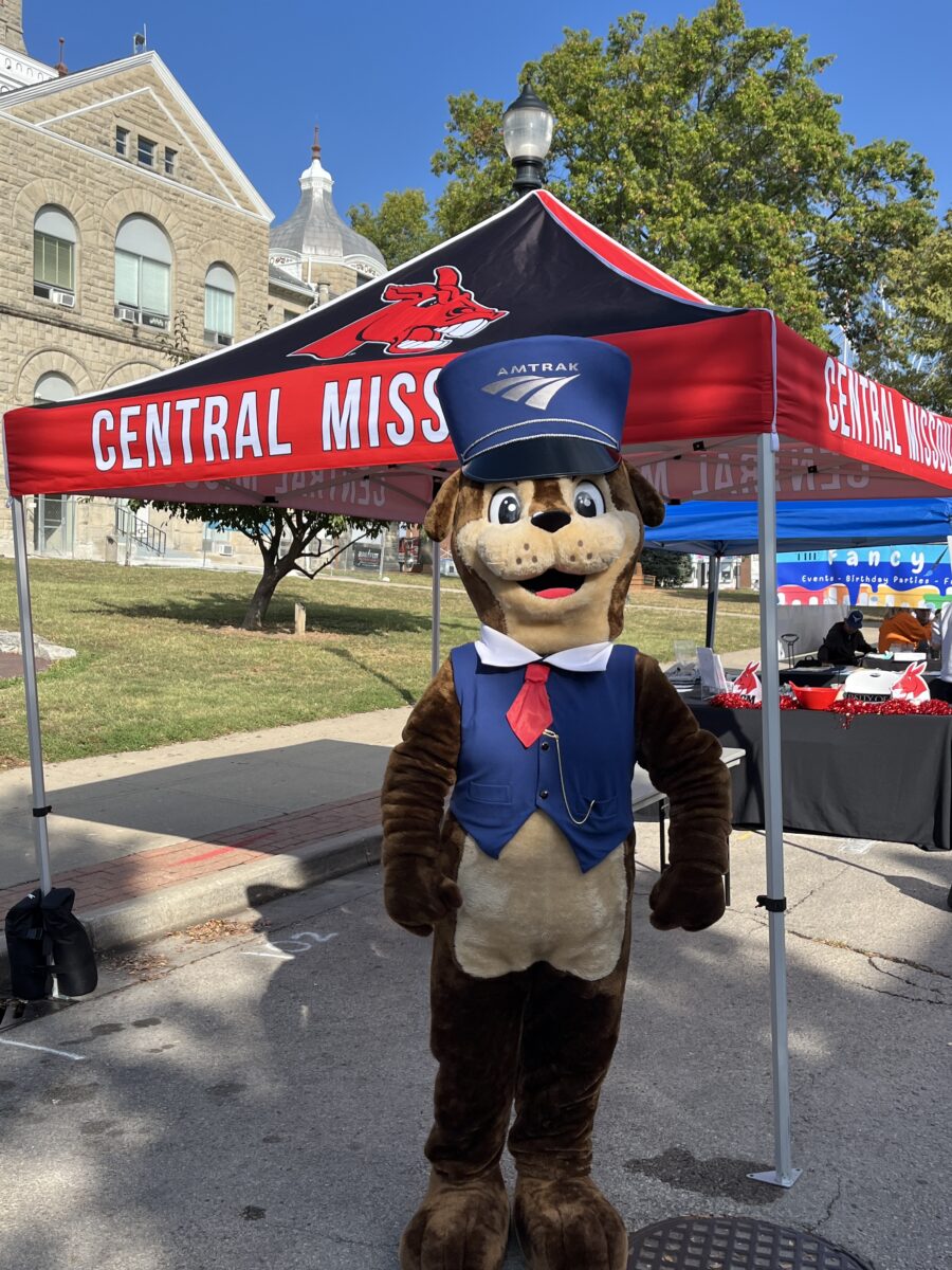 A furry train mascot outdoors at an event.