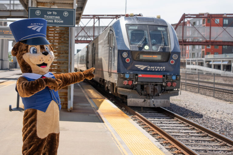 A furry mascot outside of a train station.