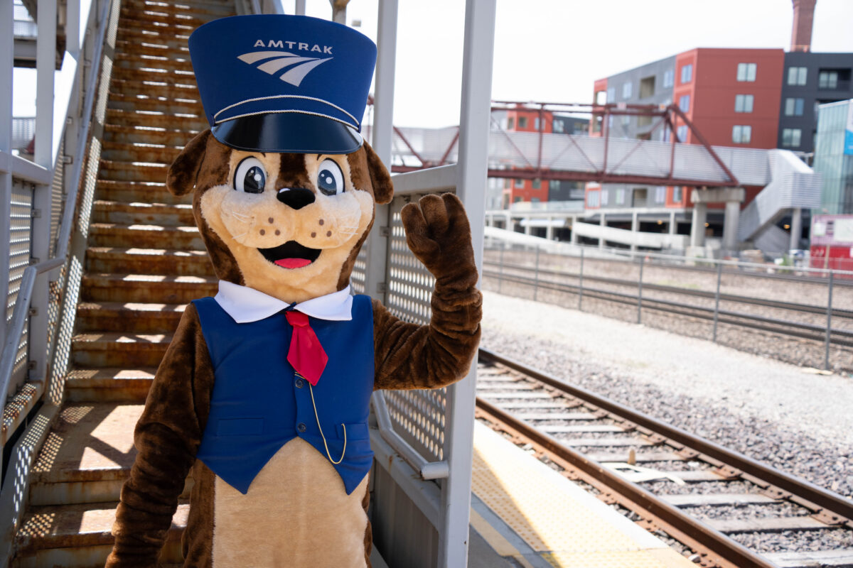 A furry mascot outside of a train station.