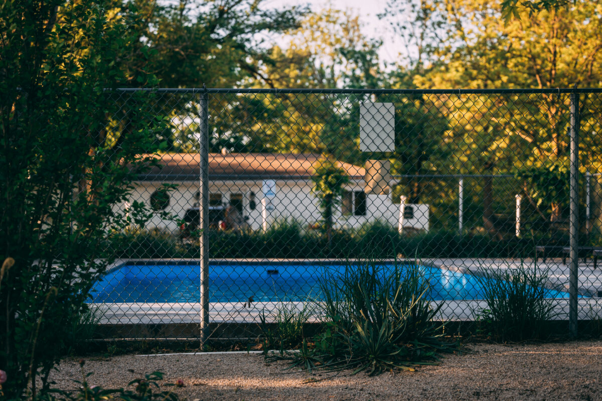 A pool and a house in the sunshine.
