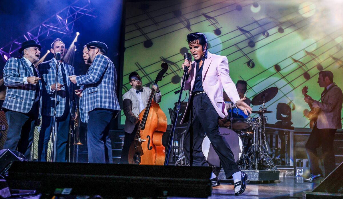A man resembling Elivs Presley performs on stage.