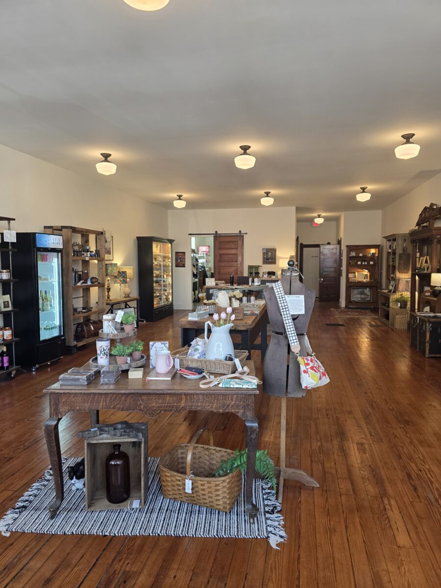 Items displayed on tables in a store with hardwood flooring.