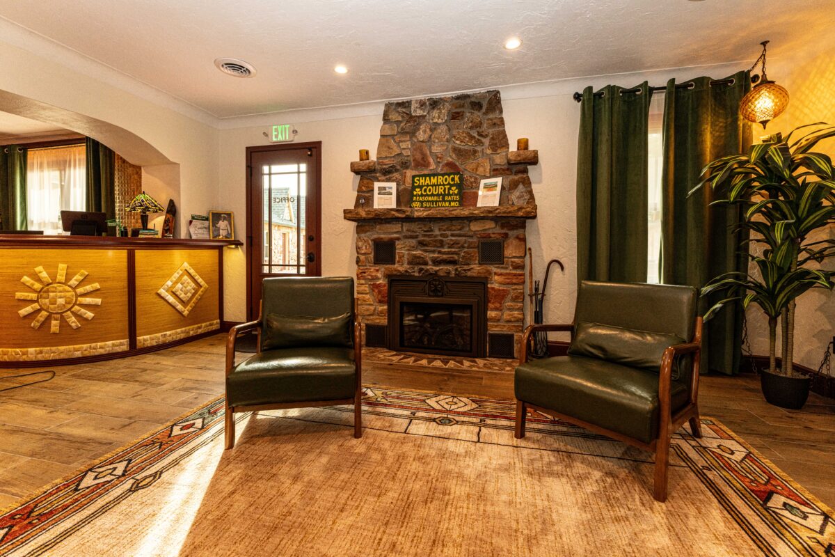 Restored Shamrock Court Motel lobby with front desk, stone fireplace and seating area