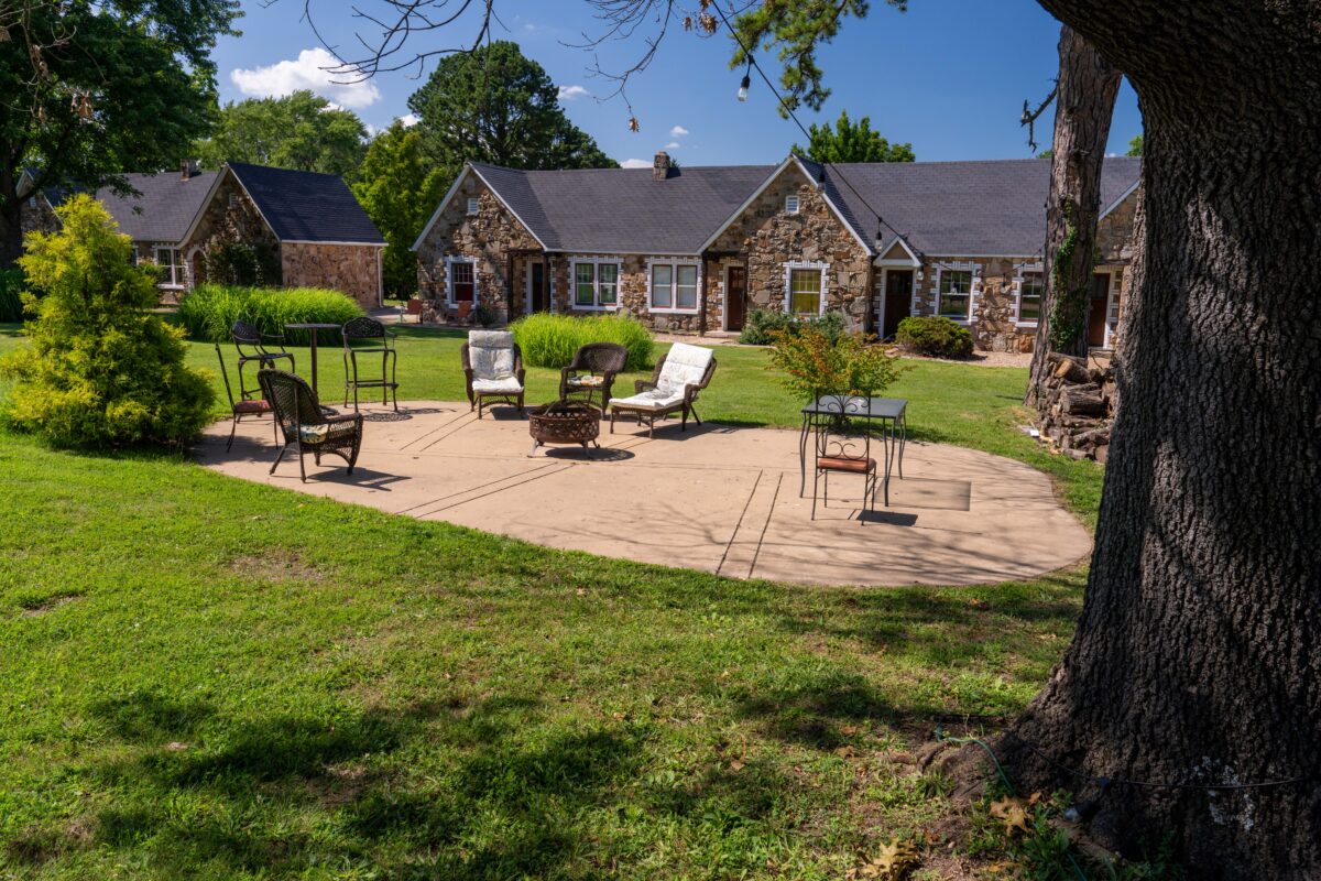 Daytime courtyard and stone guest rooms at the historic Wagon Wheel Motel