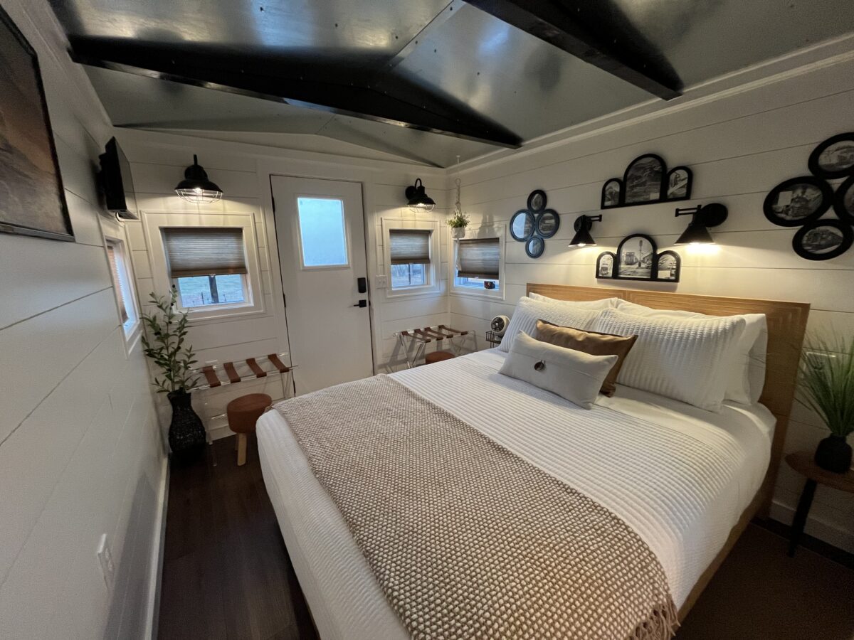 Cozy queen bedroom inside the restored 1958 train caboose at The H&R Caboose Roost in Fredericktown, Missouri.
