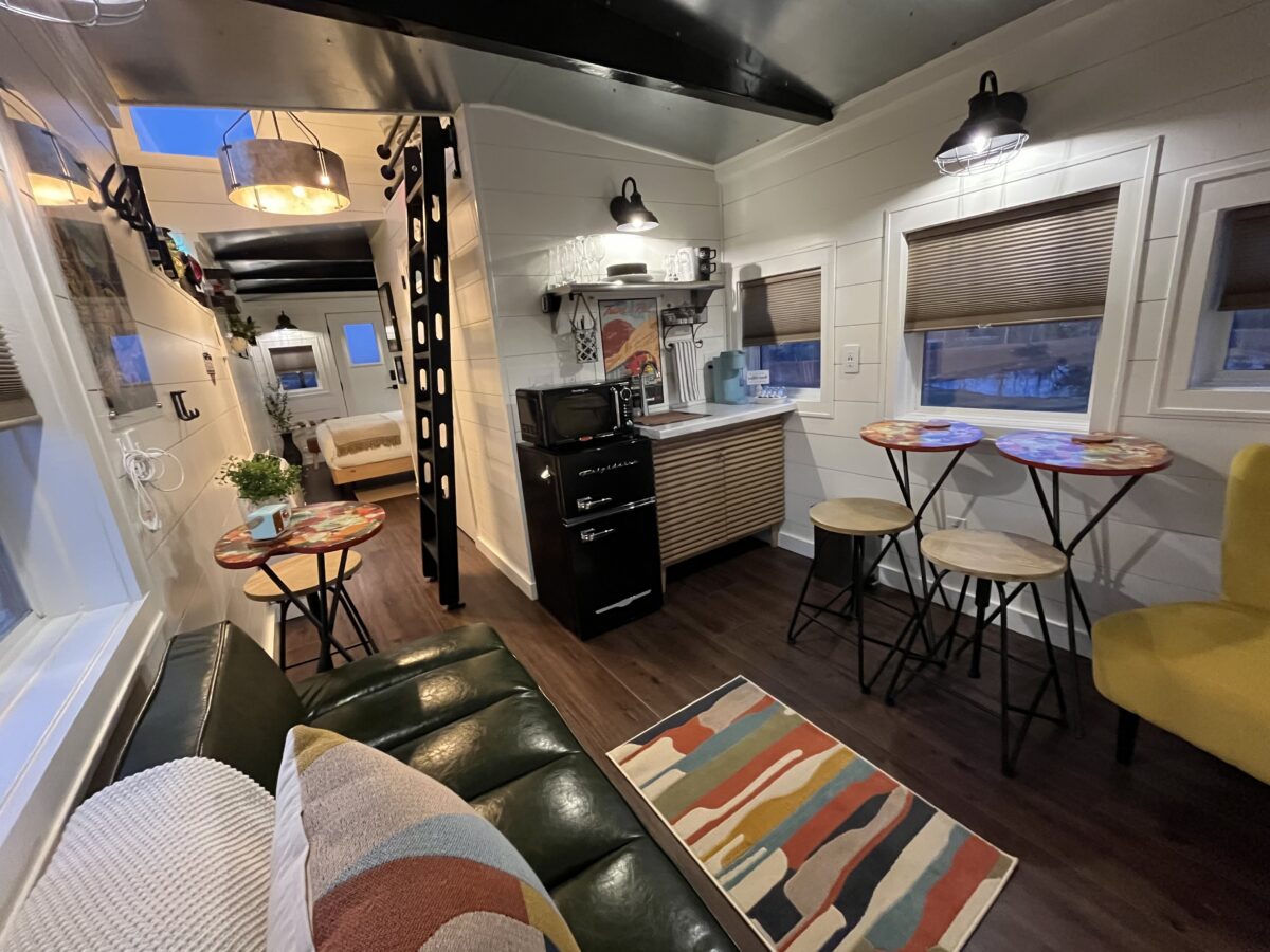 Interior of a restored 1958 train caboose featuring a cozy living area and kitchenette at The H&R Caboose Roost in Fredericktown, Missouri.
