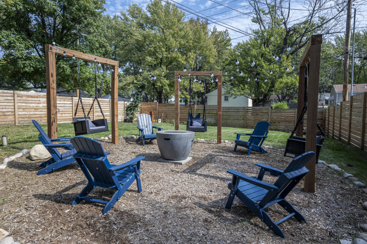 Backyard fire pit with surrounding swings at The Blue Villa in Lee's Summit.