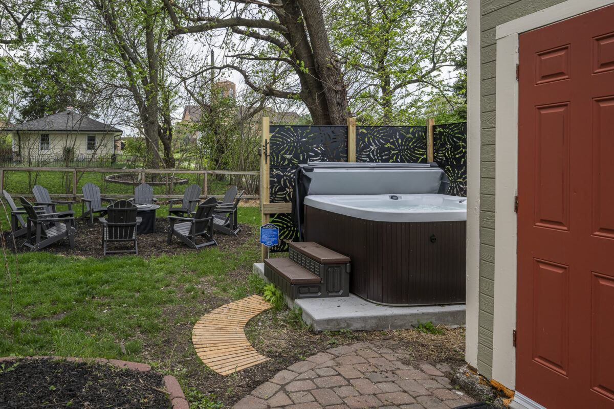 Private outdoor hot tub and gathering area at The Sage Manor vacation rental in Lee's Summit