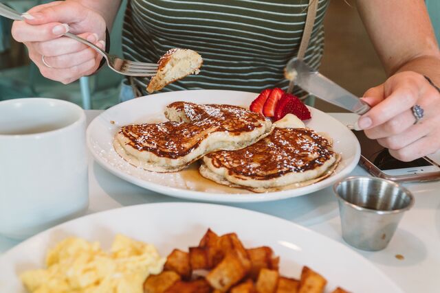 A woman eats a stack of pancakes at the Meriwether cafe and bike shop in Rocheport.