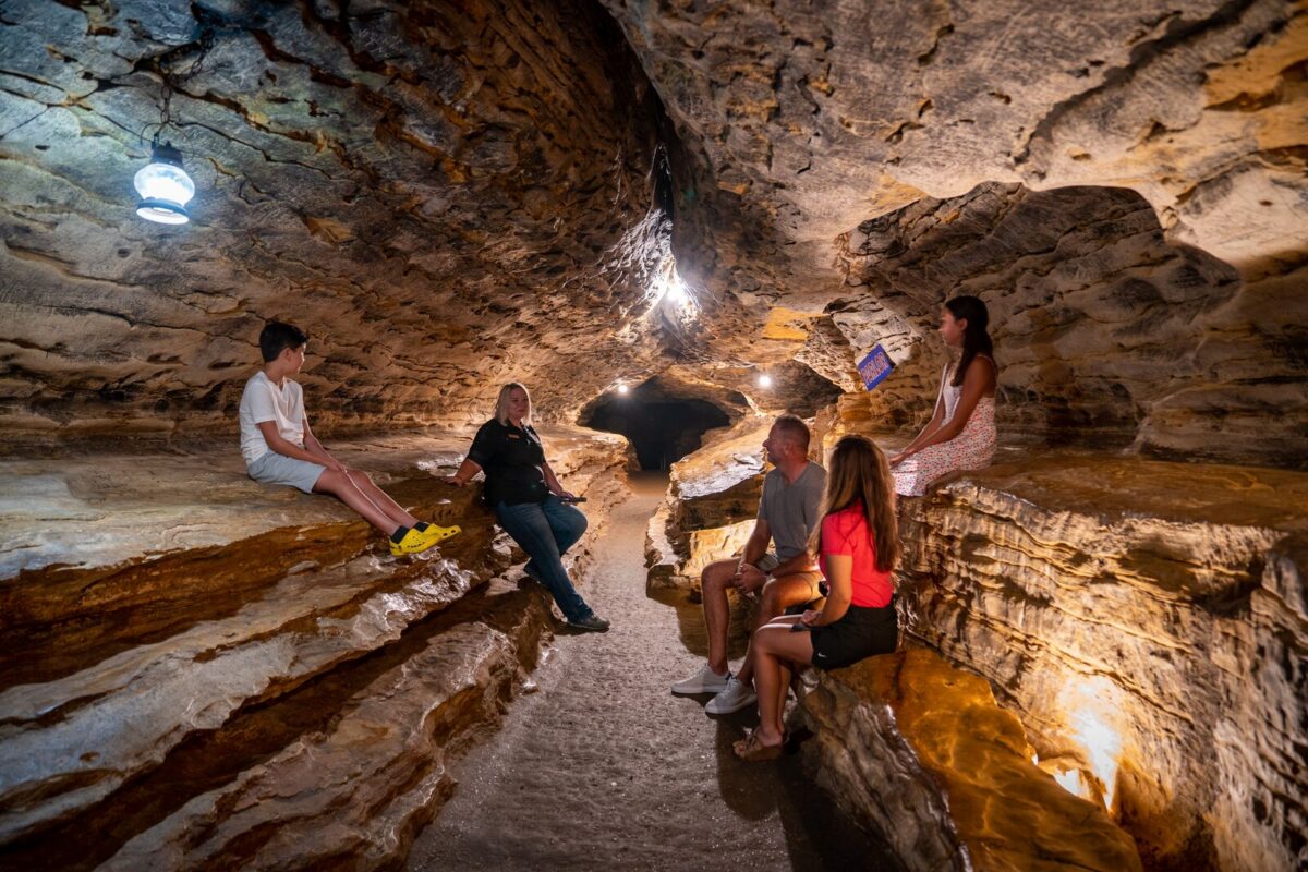 A guide shows several people Mark Twain Cave.