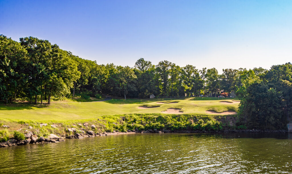 Golf course with a lake in front.